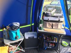 the inside of a blue tent with food and drinks on it, next to a cooler