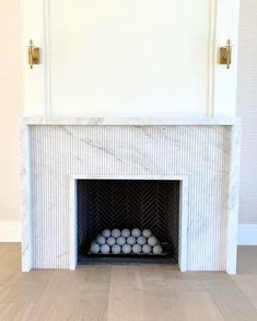 a white fireplace with some balls in it