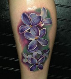 a tattoo with purple flowers on the leg