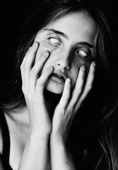 black and white photograph of a woman holding her hands to her face with eyes wide open