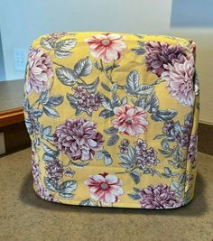 a yellow and pink flowered ottoman sitting on top of a counter