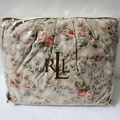 a white floral purse with the letter l on it's front and bottom corner