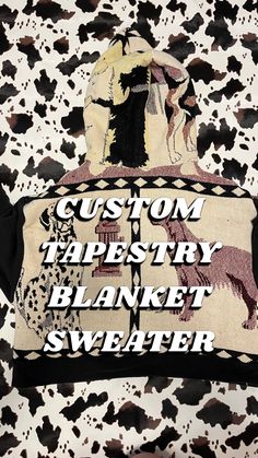 a black and white cow print pillow with the words custom tapestry blanket sweater on it