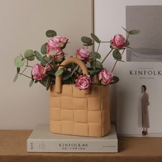 pink roses in a basket on top of a book