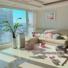 a living room filled with furniture and a large window overlooking the cityscape in the background