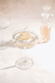 two glasses filled with drinks sitting on top of a white countertop next to each other