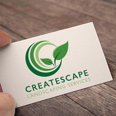 a hand holding a business card with a green leaf logo on it that reads createcape landscaping services