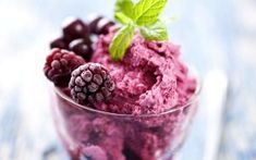 berries and ice cream in a glass bowl with mint leaves on the top, ready to be eaten