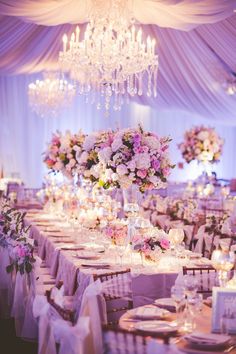 the tables are set with white linens and pink flowers, candles and centerpieces