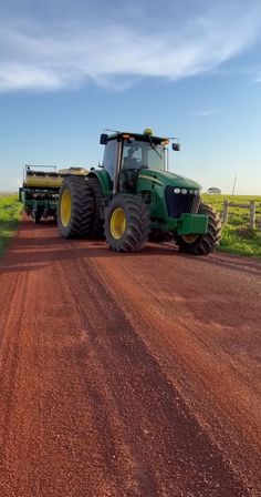 a tractor is driving down a dirt road