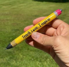 a hand holding a yellow pencil with the words teach love inspire written on it