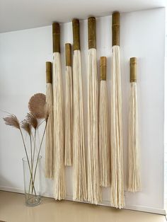 the wall is lined with bamboo poles and tassels, along with some dried flowers