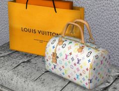 the louis vuitton bag is next to an orange shopping bag