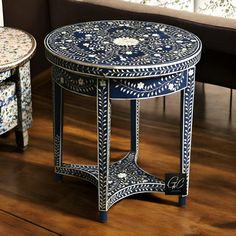 two blue and white tables sitting on top of a hard wood floor next to a couch