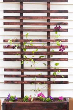 a wooden planter with purple flowers in it