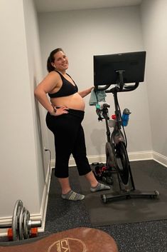 a woman standing next to a bike in a room