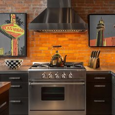 a stove top oven sitting inside of a kitchen next to a wall with pictures on it