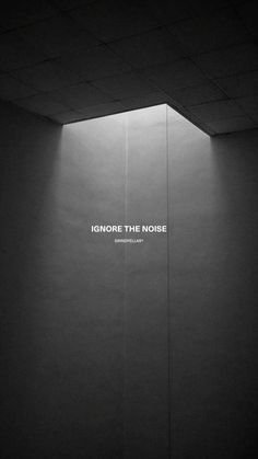 the words ignore the noise are displayed on a wall in an empty room with no people