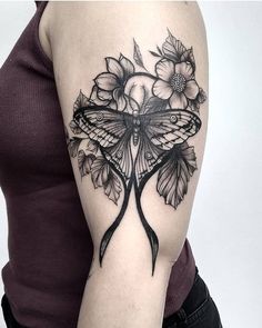 a woman's arm with a butterfly and flowers tattoo on the left side of her arm