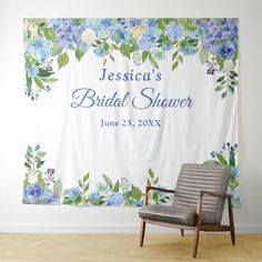 a chair sitting in front of a white wall with blue flowers on it and the name jenny