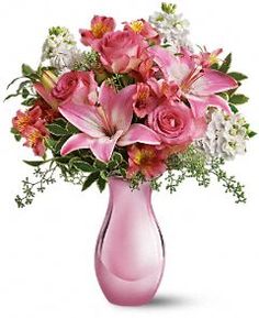 a pink vase filled with lots of flowers