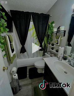 a bathroom with black and white decor in the shower curtain, toilet, sink and mirror