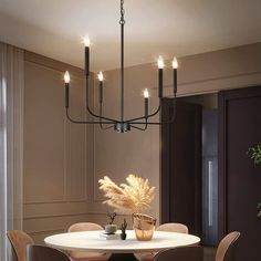 a dining room table with chairs and a chandelier hanging from the ceiling above it