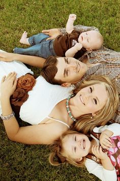 three women laying on the grass with their arms around each other