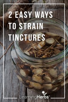 a glass jar filled with mushrooms on top of a wooden table next to some roots