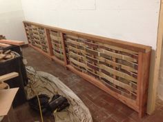 a wooden bench sitting on top of a floor next to a pile of wood planks