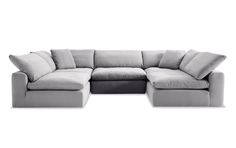 a large sectional couch with pillows on it's back and side facing the camera