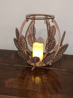 a candle holder with an intricate design on the front and sides, sitting on a wooden table