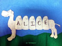 the word alice spelled in cut out letters with a camel on it's back