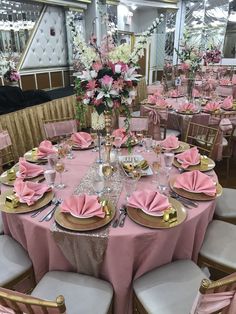 the tables are set with pink napkins and gold place settings