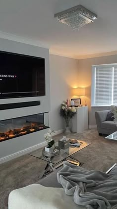 a living room filled with furniture and a flat screen tv mounted on the wall above a fireplace