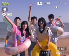 a group of people standing on top of a beach next to an inflatable raft