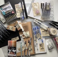 an assortment of pens, pencils and markers on a table