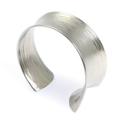 Think making a bold statement with your bracelet means piling on a lot of sparkly gemstones? Think again! The John S. Brana Tapered Bark Anticlastic Aluminum Bangle Bracelet keeps your look sleek and modern while still setting you apart from the crowd. This gorgeous handcrafted bracelet has a striking high shine finish that catches the eye from afar, and up close, its bark-like texture is incredibly elegant.Versatile and very modern, the John S. Brana Tapered Bark Anticlastic Aluminum Bangle Bra Modern Metal Bracelets For Jewelry Making, Adjustable Metal Cuff Bracelet For Anniversary, Handmade Metal Cuff Bracelet For Anniversary, Modern Handmade Bracelets For Anniversary, Metal Cuff Bracelet Bangle For Anniversary, Modern Adjustable Bangle For Anniversary, Modern Nickel-free Cuff Bracelet For Gift, Modern Nickel-free Cuff Bracelet As Gift, Aluminum Bracelets