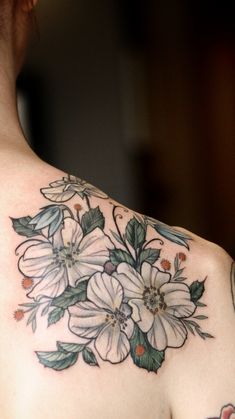 the back of a woman's shoulder with flowers on it