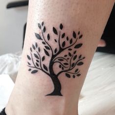 a black and white tree tattoo on the leg