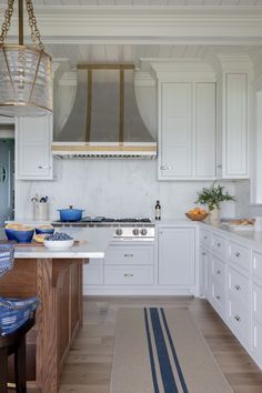 a kitchen with white cabinets and blue accents