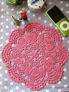 a pink doily sitting on top of a table next to ipods and other items