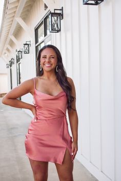 a woman in a pink dress posing for the camera