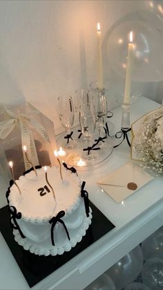 a birthday cake with candles on it sitting on top of a table next to other items