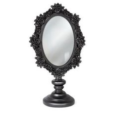 an ornate black vanity mirror on a stand