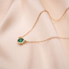 Our 14k Emerald Bezel Necklace features a lustrous bright, and ethically-sourced genuine emerald. This necklace is ideal for layering but easily a statement when worn on its own. 14k Gold and genuine Zambian Emerald Approximately .55 CTW 5.2mm stone dimension 14k Cable Chain Available in lengths 16" and 18" Due to the handmade nature of this necklace, please allow 1 - 3 weeks for processing. Minimalist Emerald Necklace In Yellow Gold, Dainty Gold Emerald Birthstone Necklace, Emerald Necklace With Delicate Yellow Gold Chain, Yellow Gold Emerald Necklace With Delicate Chain, Delicate Yellow Gold Emerald Necklace, Emerald Necklaces For Everyday Wear, May Birthstone, Emerald Necklace For Everyday Wear - May Birthstone, Emerald Necklace For Everyday Wear, Minimalist Yellow Gold Emerald Necklace