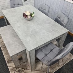 a dining table with chairs around it and a bowl of flowers on the table top