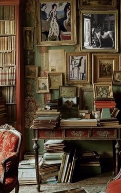 a room filled with lots of books and pictures on the wall next to a chair