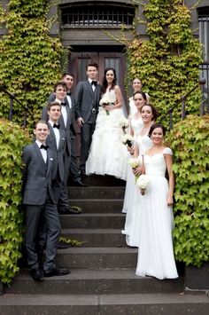 a group of people that are standing in front of some stairs with ivy on them