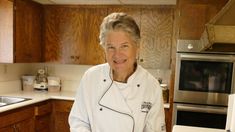 an older woman is standing in the kitchen